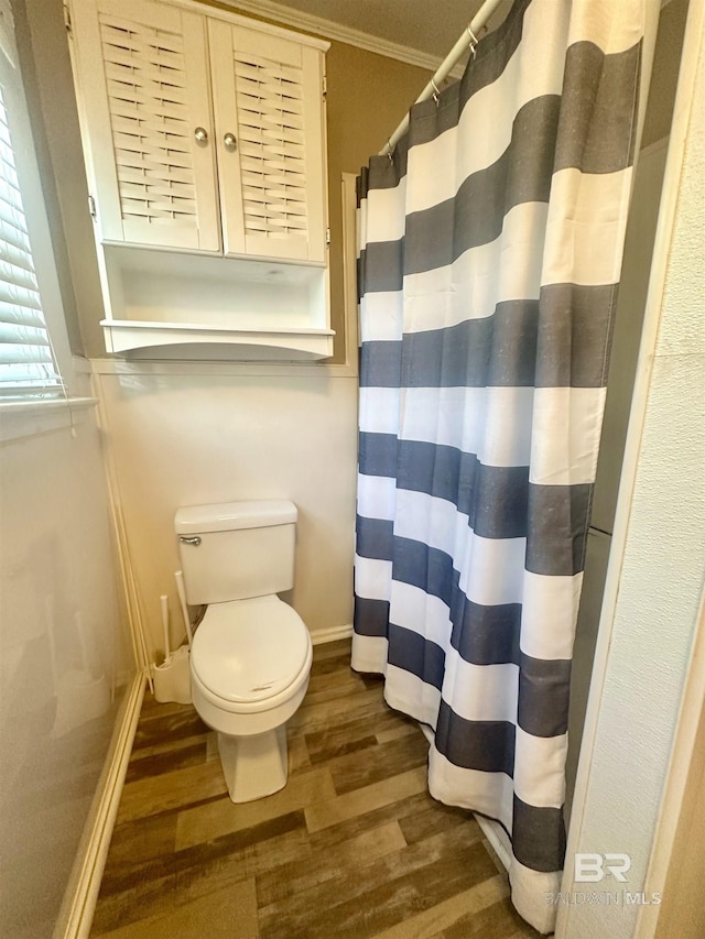 bathroom featuring crown molding, hardwood / wood-style floors, and toilet