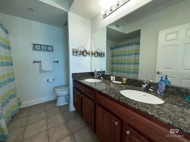 bathroom featuring tile patterned floors, double vanity, toilet, and a sink