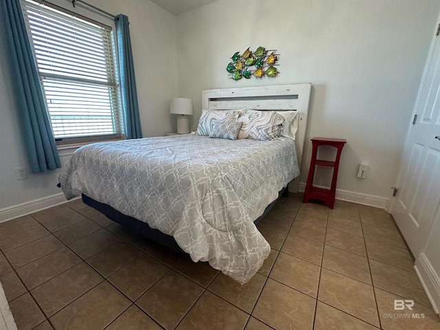 tiled bedroom featuring baseboards