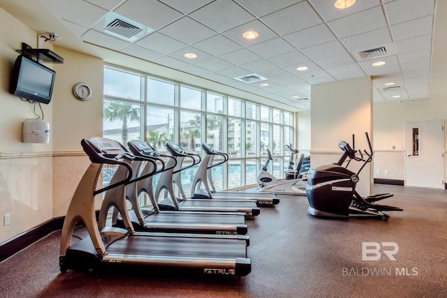 gym featuring a drop ceiling, visible vents, and a wall of windows