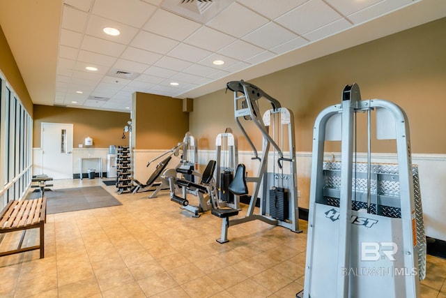 gym with a drop ceiling, visible vents, recessed lighting, and wainscoting