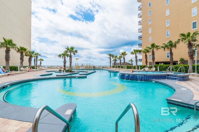 view of swimming pool with a hot tub