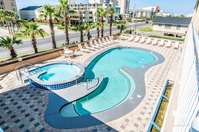 view of pool with a pool with connected hot tub and a patio area