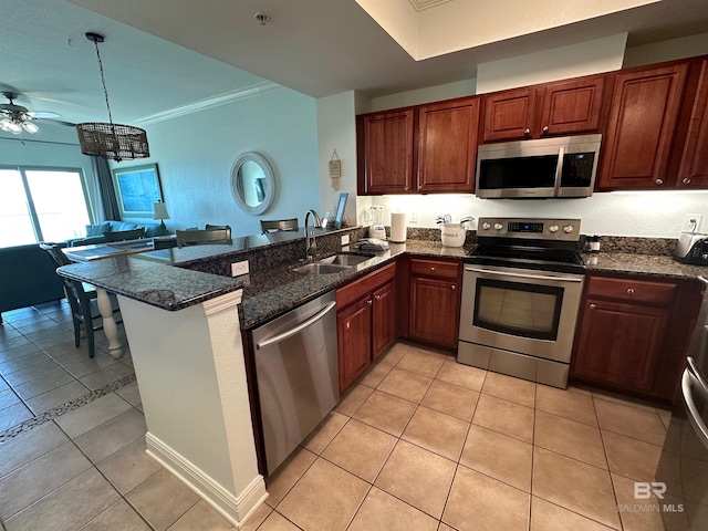 kitchen with open floor plan, ornamental molding, a peninsula, stainless steel appliances, and a sink