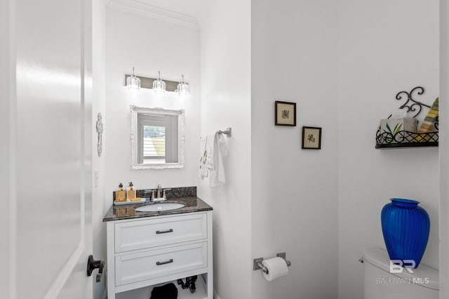 bathroom featuring vanity, toilet, and crown molding