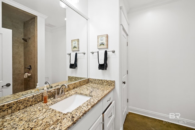 bathroom featuring vanity, crown molding, and a tile shower