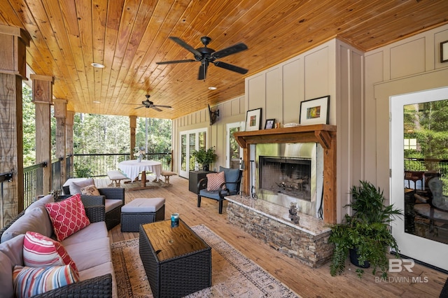 exterior space with an outdoor stone fireplace, ceiling fan, and wooden ceiling