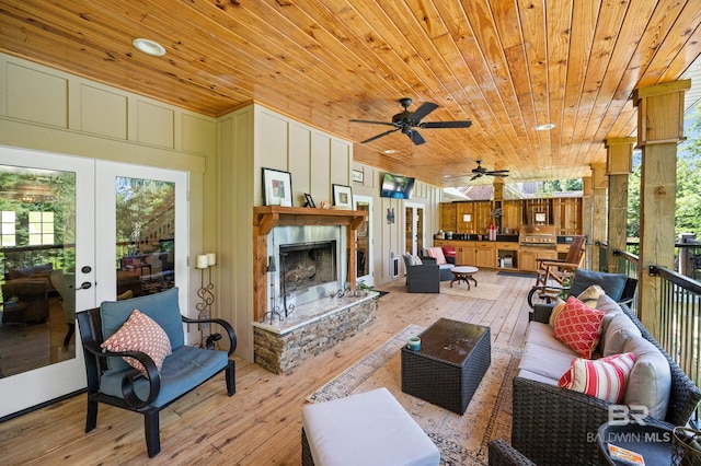 living room featuring french doors, light hardwood / wood-style floors, a healthy amount of sunlight, and wood ceiling