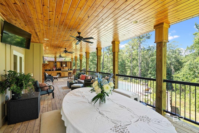 wooden terrace with an outdoor living space and ceiling fan