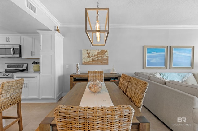 tiled dining room with a textured ceiling and crown molding