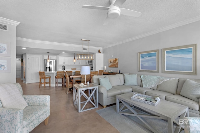 living room with ceiling fan, a textured ceiling, and ornamental molding