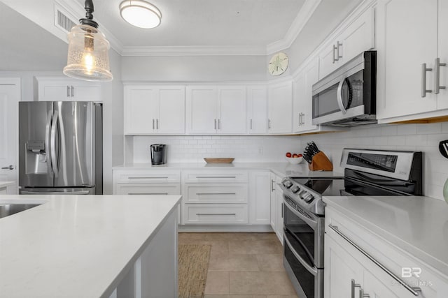 kitchen with white cabinets, light tile patterned floors, decorative light fixtures, backsplash, and appliances with stainless steel finishes