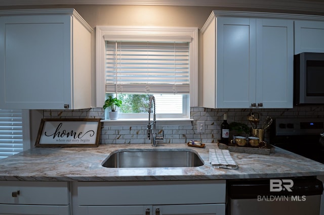 kitchen with a sink, light stone countertops, tasteful backsplash, and stainless steel appliances