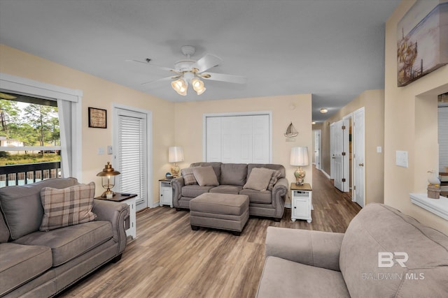 living room with wood-type flooring and ceiling fan