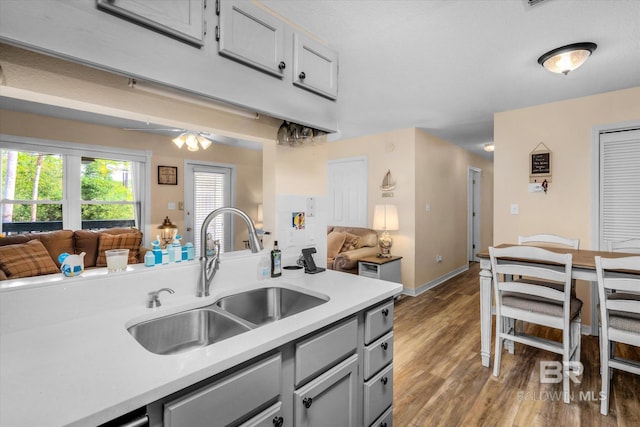 kitchen with ceiling fan, hardwood / wood-style floors, sink, and gray cabinetry