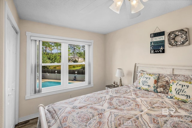 bedroom with a textured ceiling, hardwood / wood-style flooring, ceiling fan, and a closet