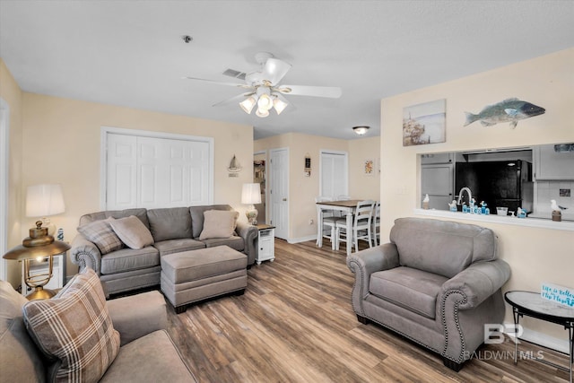 living room with sink, ceiling fan, and hardwood / wood-style flooring