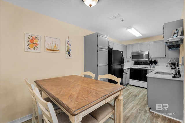 dining space featuring sink and light hardwood / wood-style flooring