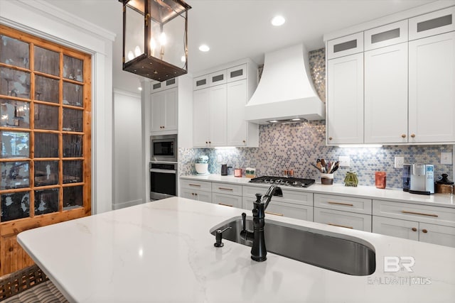 kitchen featuring custom exhaust hood, white cabinetry, decorative backsplash, and stainless steel appliances