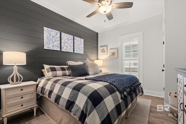 bedroom featuring wood walls, ceiling fan, crown molding, and dark hardwood / wood-style floors