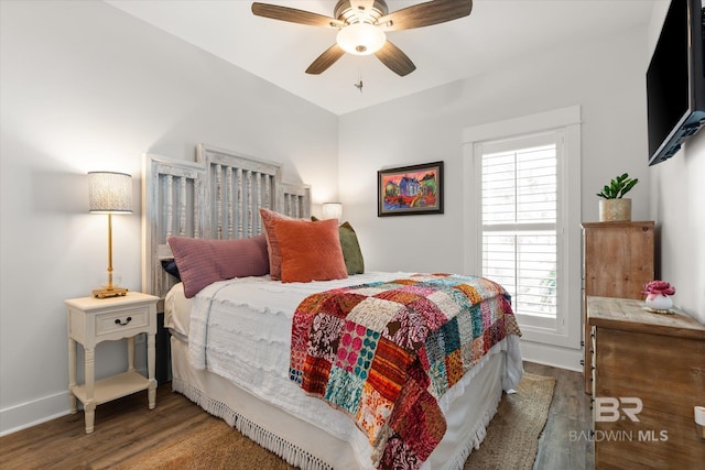 bedroom featuring ceiling fan, dark hardwood / wood-style flooring, and multiple windows