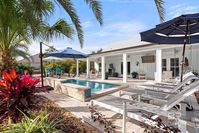 view of swimming pool with a hot tub and a patio area