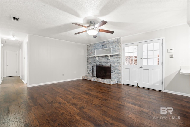 unfurnished living room with ceiling fan, a fireplace, dark hardwood / wood-style flooring, and a textured ceiling