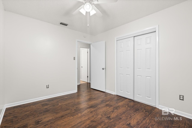 unfurnished bedroom featuring dark hardwood / wood-style flooring, a closet, and ceiling fan