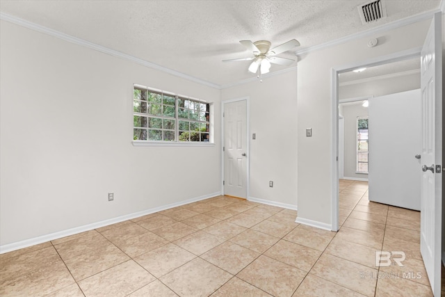 unfurnished room with crown molding, a healthy amount of sunlight, light tile patterned flooring, and a textured ceiling