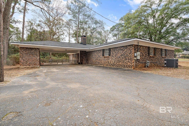 view of side of home with central AC and a carport