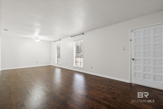 empty room with ceiling fan, dark hardwood / wood-style floors, and a textured ceiling