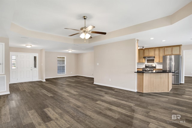 unfurnished living room with a raised ceiling, baseboards, and dark wood-style flooring