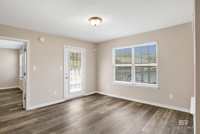 empty room featuring wood finished floors and baseboards