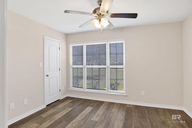 spare room featuring baseboards, wood finished floors, and a ceiling fan