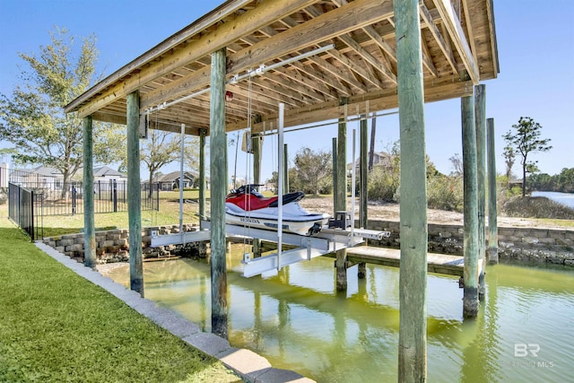 view of dock with a yard, a water view, boat lift, and fence