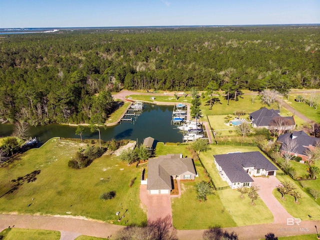 birds eye view of property with a view of trees and a water view