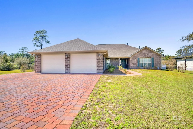 view of front of house featuring brick siding, an attached garage, decorative driveway, and a front lawn