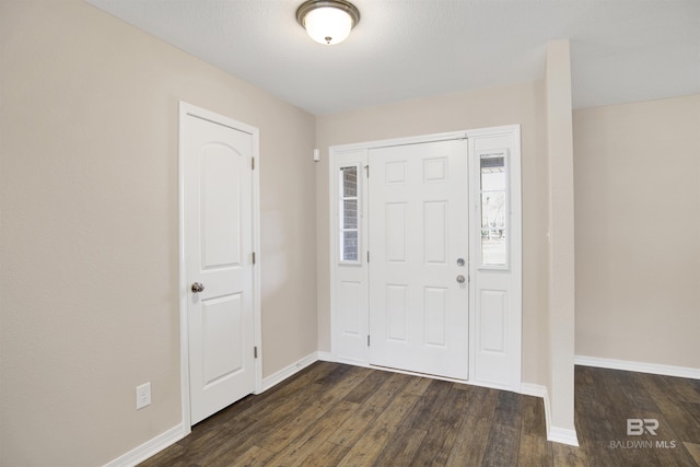 entryway featuring dark wood-type flooring and baseboards