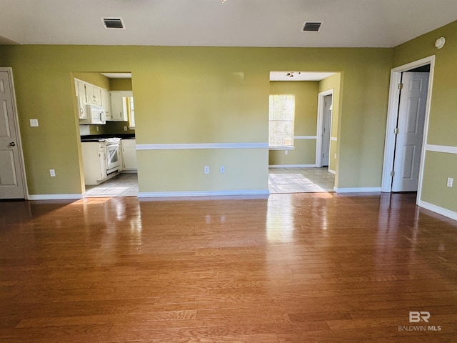unfurnished room featuring visible vents, baseboards, and light wood-style floors