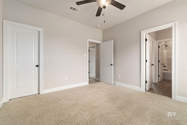 unfurnished bedroom with light colored carpet, ensuite bath, and ceiling fan