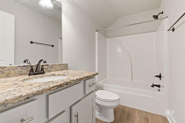 full bathroom featuring vanity, vaulted ceiling, hardwood / wood-style flooring, toilet, and shower / bathtub combination