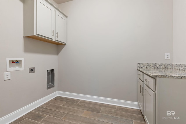 washroom featuring hookup for an electric dryer, cabinets, dark wood-type flooring, and washer hookup