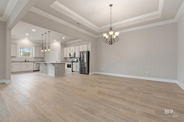 kitchen with white cabinetry, appliances with stainless steel finishes, pendant lighting, a kitchen island, and light wood-type flooring