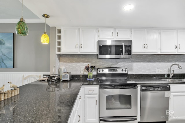 kitchen with stainless steel appliances, a sink, white cabinetry, ornamental molding, and pendant lighting