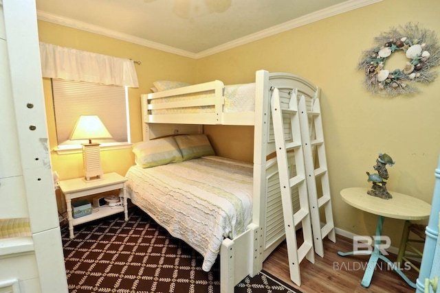 bedroom with ornamental molding, baseboards, and wood finished floors