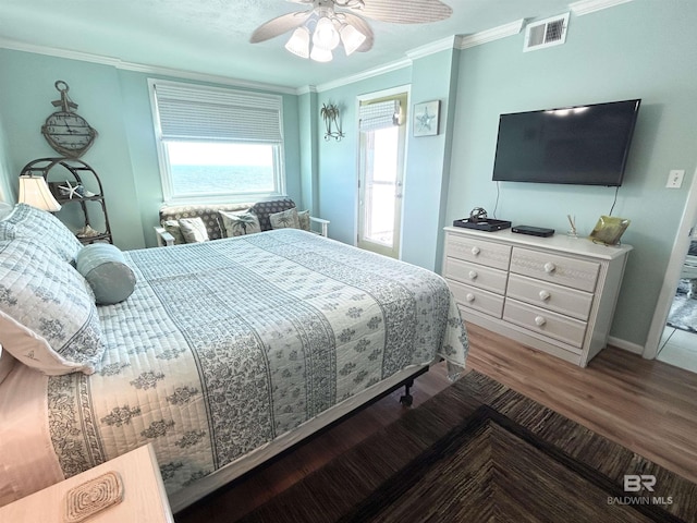 bedroom with ceiling fan, ornamental molding, wood finished floors, and visible vents