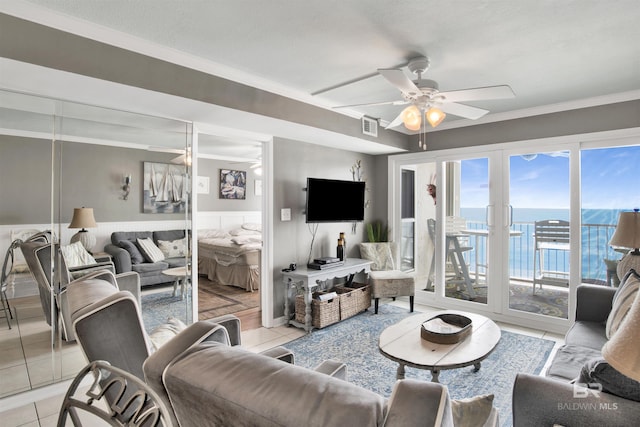 living room with ornamental molding, ceiling fan, and light tile patterned floors