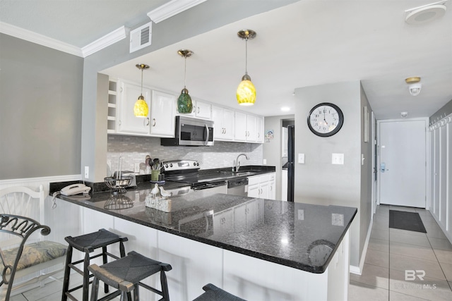 kitchen with visible vents, ornamental molding, a peninsula, stainless steel appliances, and a sink