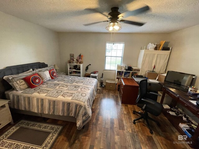 bedroom with dark hardwood / wood-style flooring, a textured ceiling, and ceiling fan