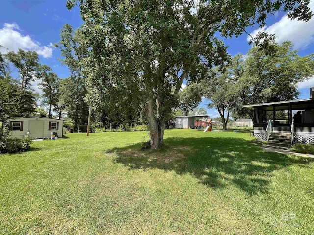 view of yard with a playground and a storage shed